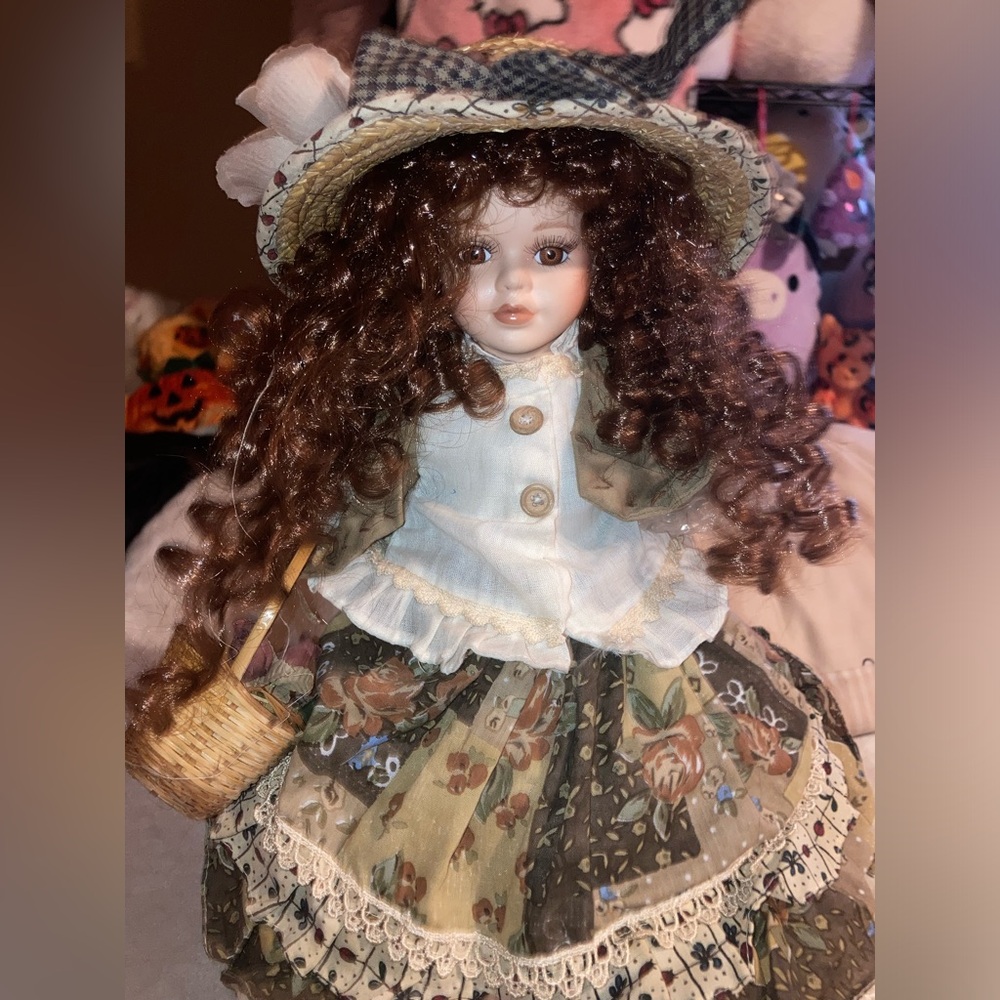 Porcelain doll with brown curly hair holding a basket lamp